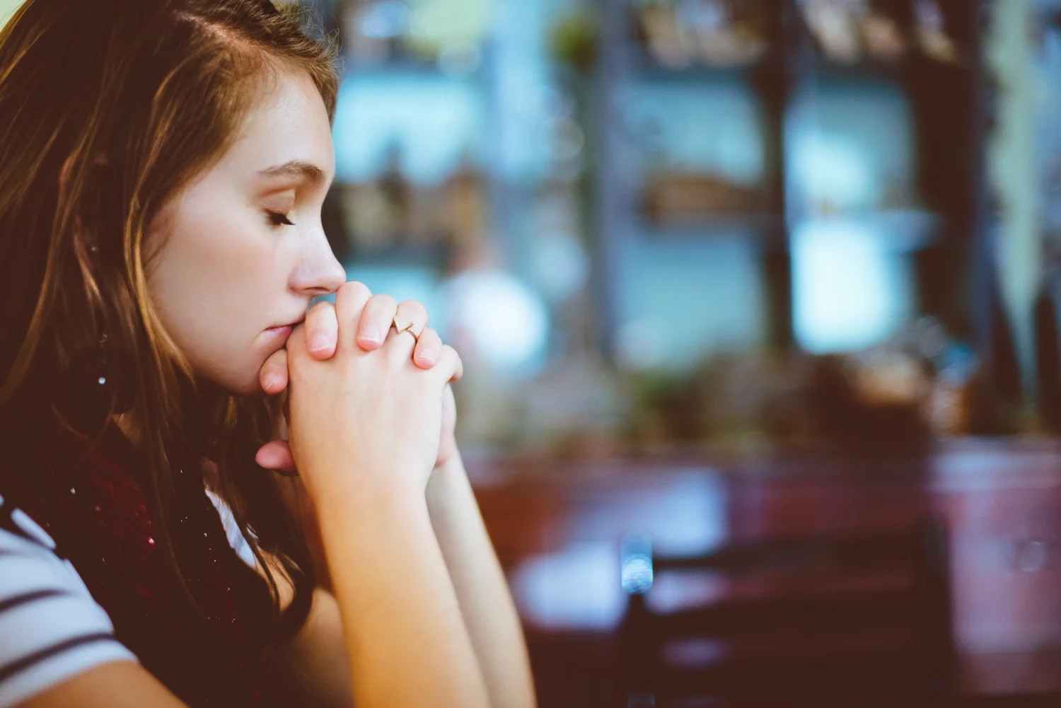 A person resting their chin on their clasped hands