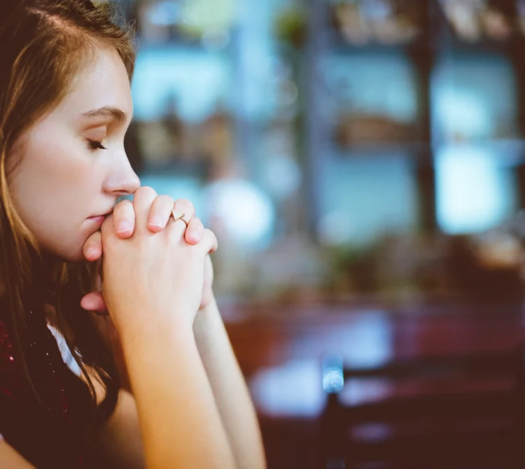 A person resting their chin on their clasped hands