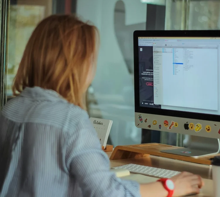 back of a women leaning forward on a computer