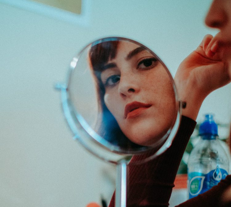 Women looking at her face in mirror