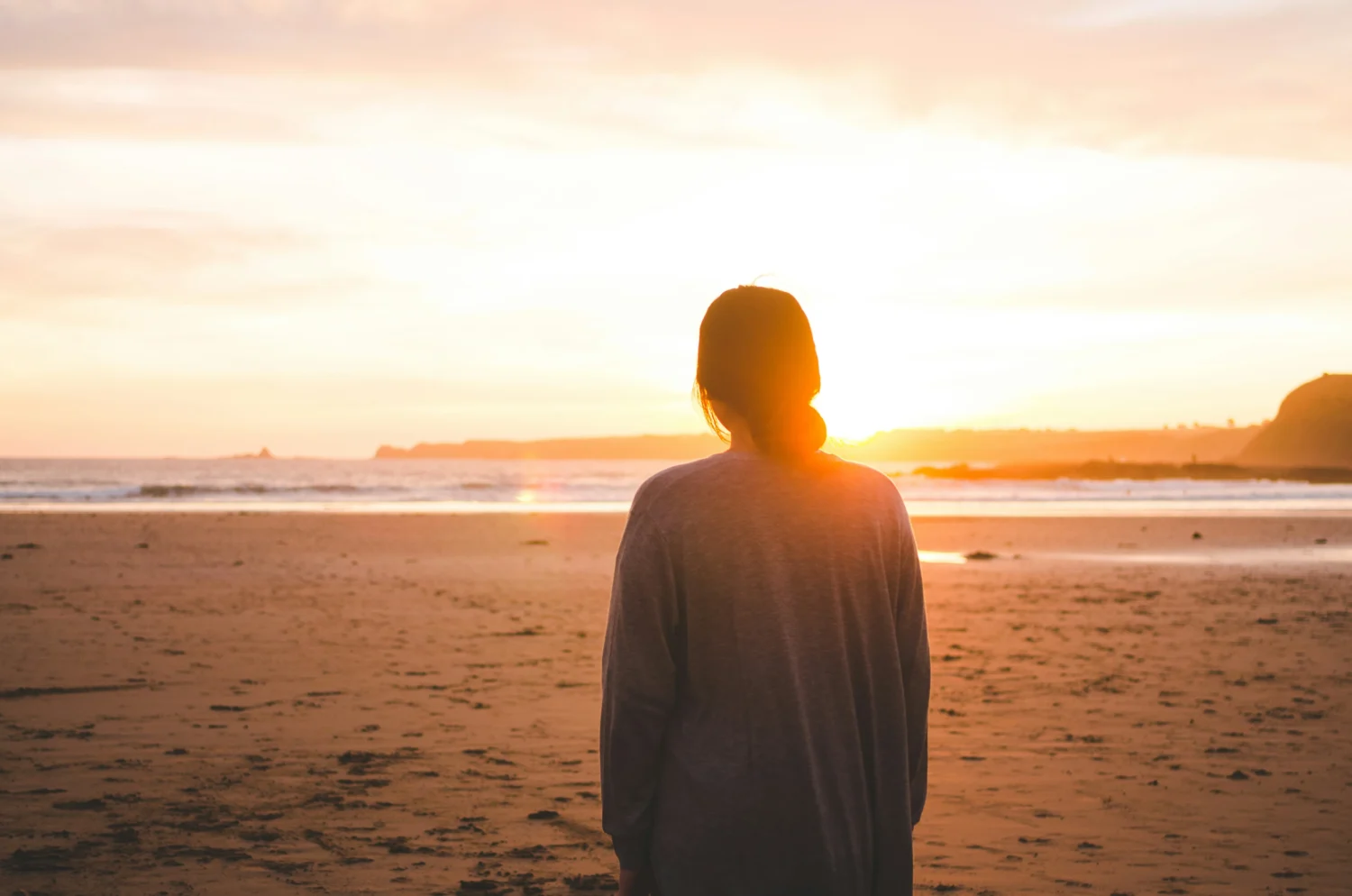 Back of women standing in the sunset on the beach