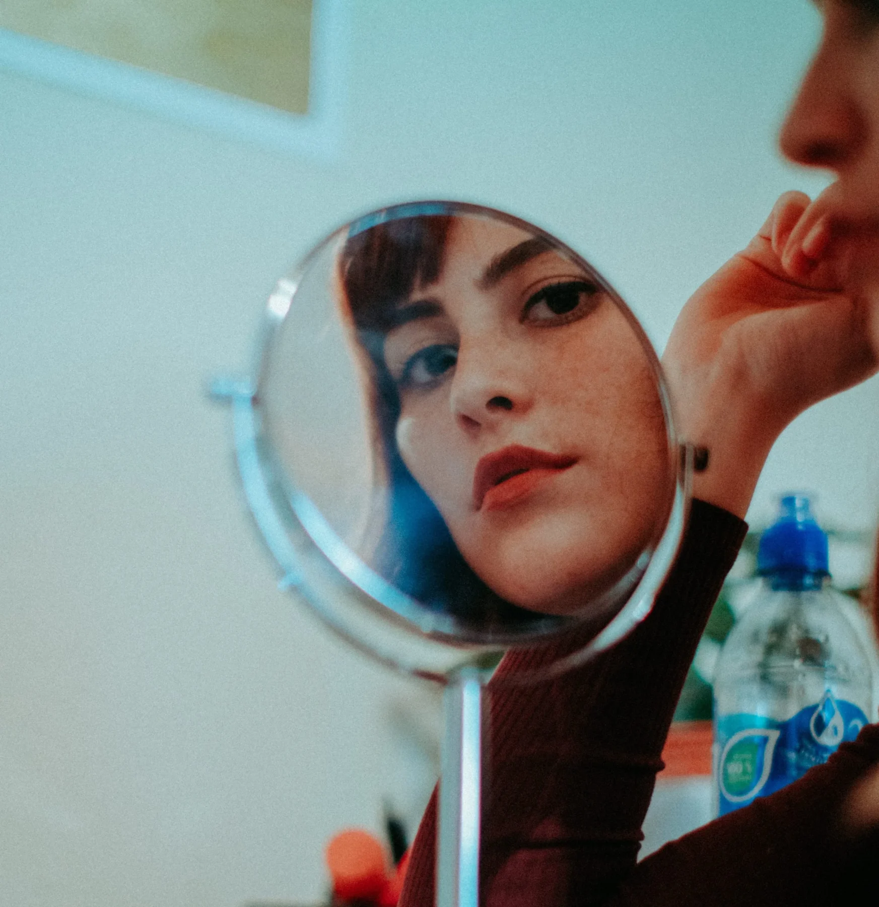 Women looking in small mirror at her face