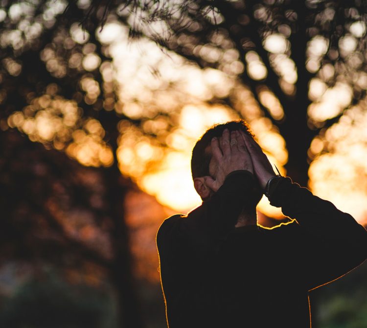 Man with hands on his face looking up