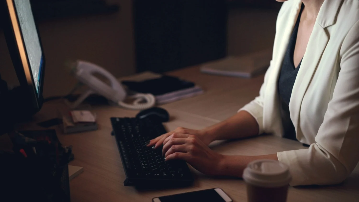 A woman sitting at her desk late at night
