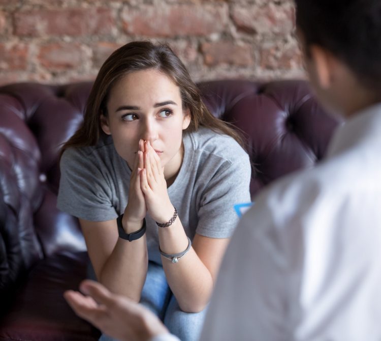 Young women sitting on couch talking to therapist