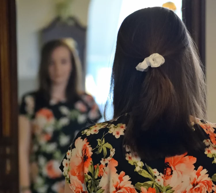 View of the back of a person head who is standing in front of mirror