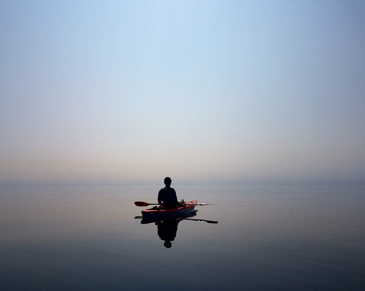 Person kayaking calm waters