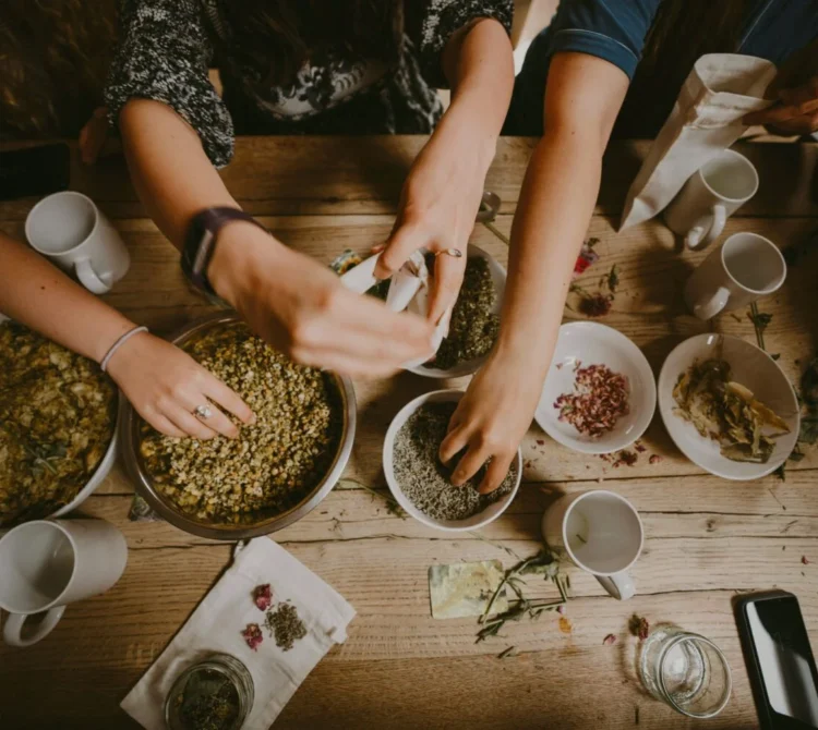 Several people preparing food together around a table.