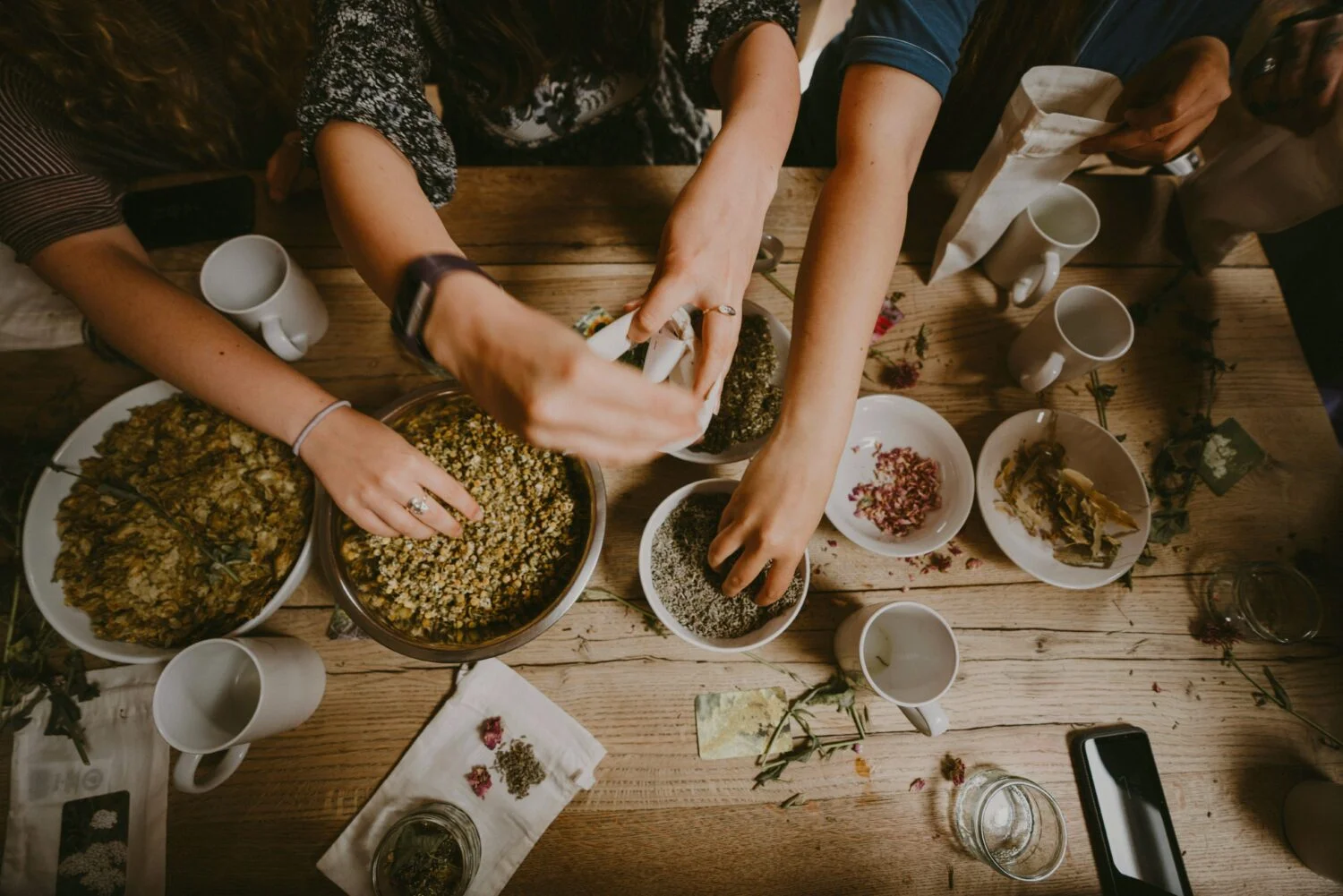 Several people preparing food together around a table.