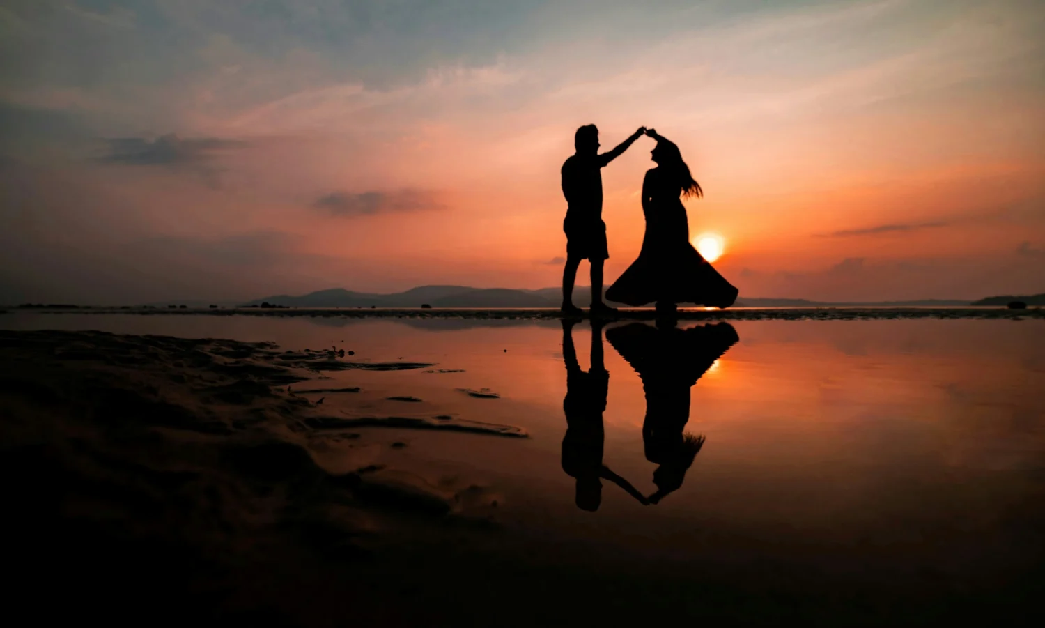 couple dancing together in the sunset