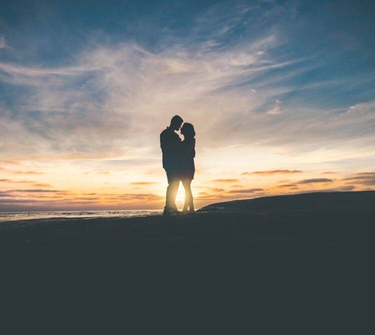Couple in the distance as a silhouette in sunset talking very closely