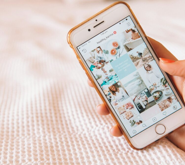 A hand holding an iPhone showing a wellness-based instagram page