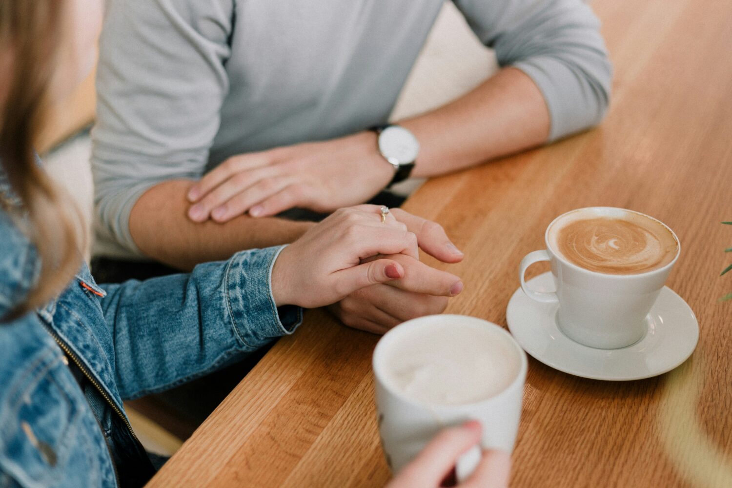 Couple holding hands at cafe