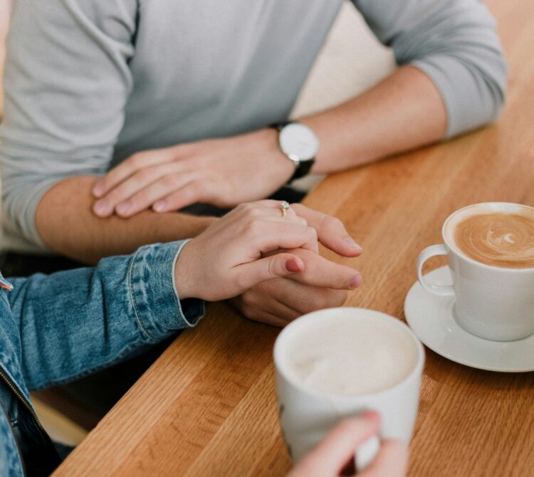 Couple holding hands at cafe