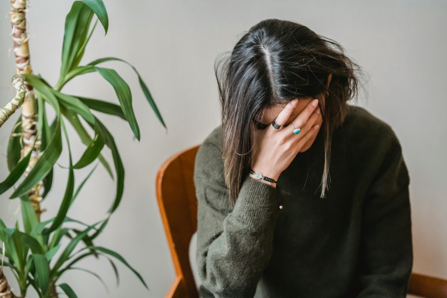 Woman holding head in hand.