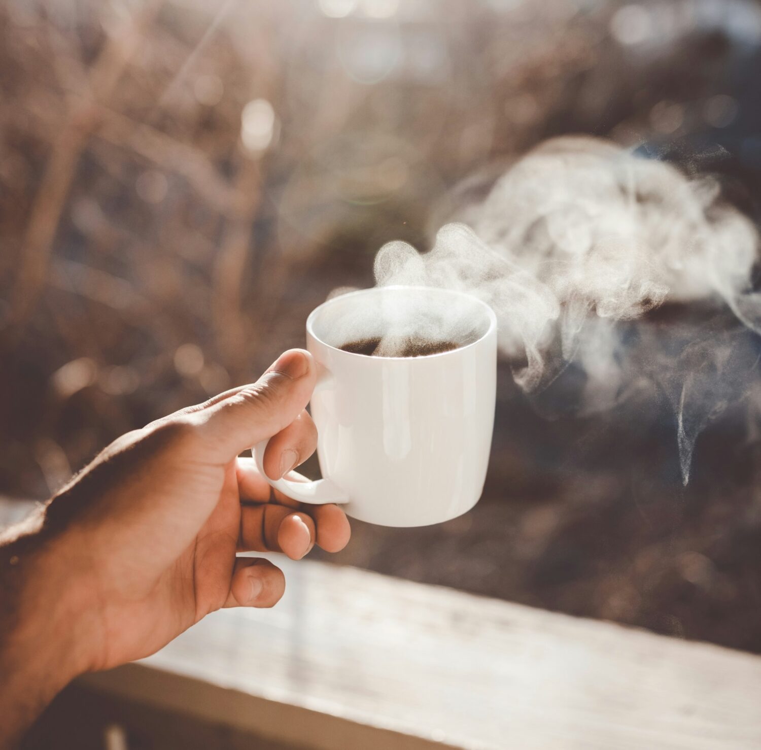 Person holding coffee cup with steam