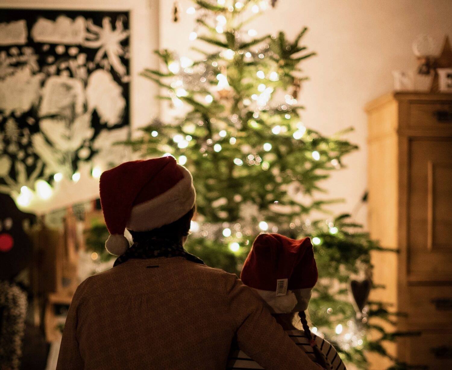 Two people hugging and looking at a Christmas Tree