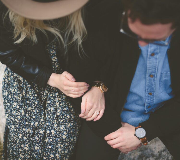 Birds eye view of two people holding hands