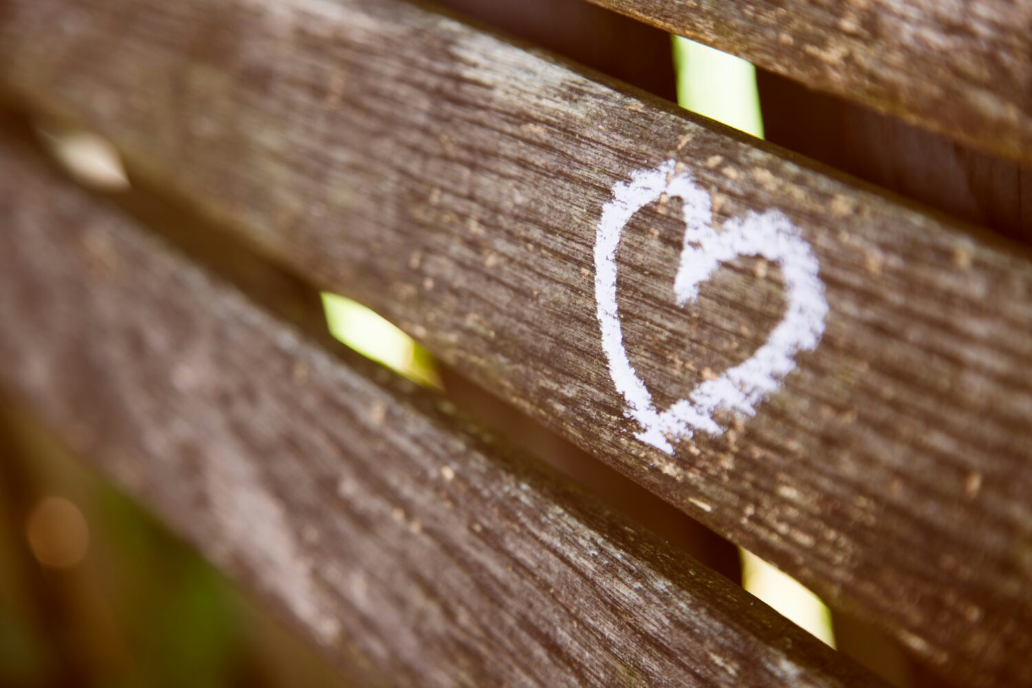 Love heart drawn with chalk on wooden bench