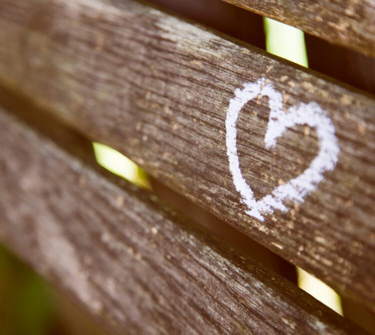 Love heart drawn with chalk on wooden bench