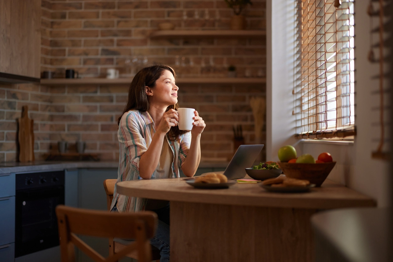 Women sitting at kitchen table looking out the window smiling