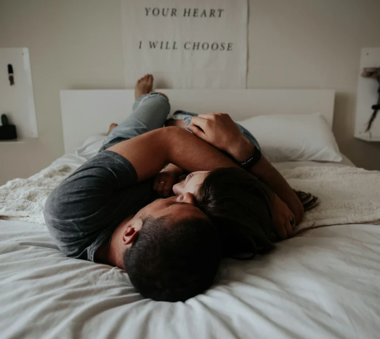 A couple cuddling on a bed