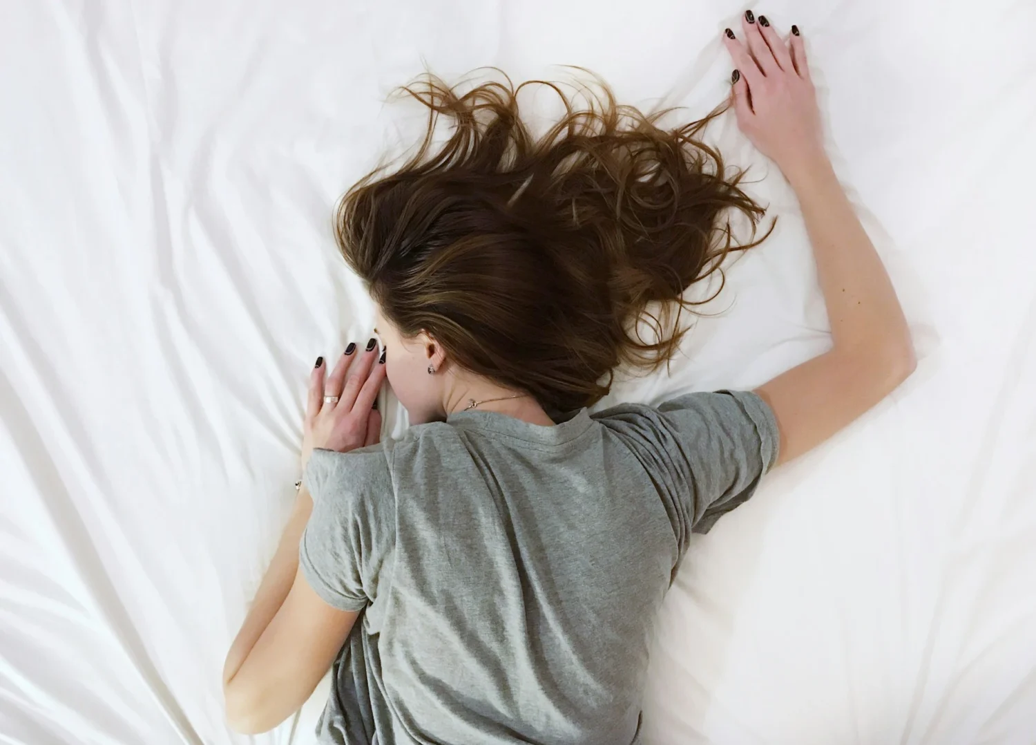 A woman lying face down on a bed