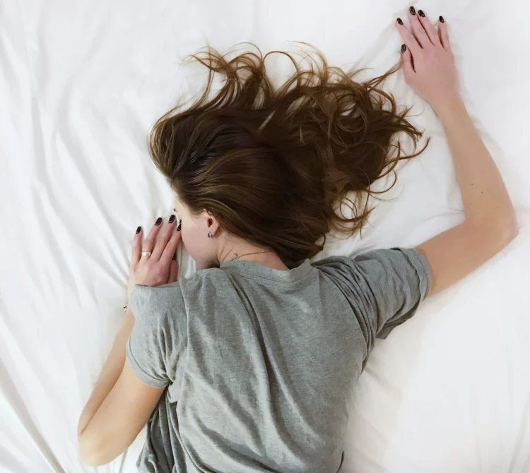 A woman lying face down on a bed